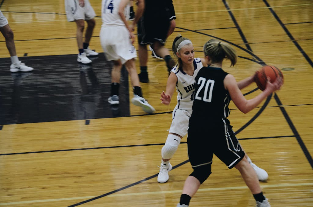 Dynamic shot of a women's basketball game with players in action on the court.
